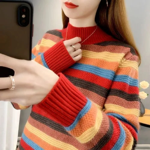 Person wearing a colorful striped sweater taking a mirror selfie.