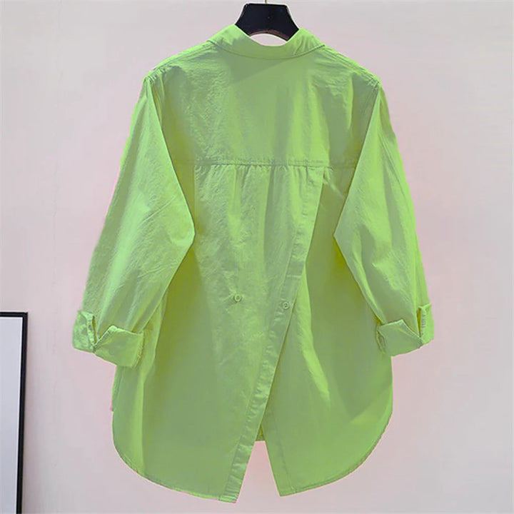 Neon green shirt on a hanger against a plain background