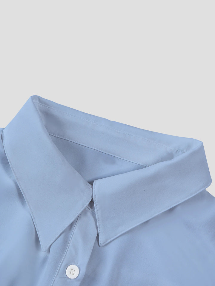 Close-up of a light blue shirt collar on a plain background