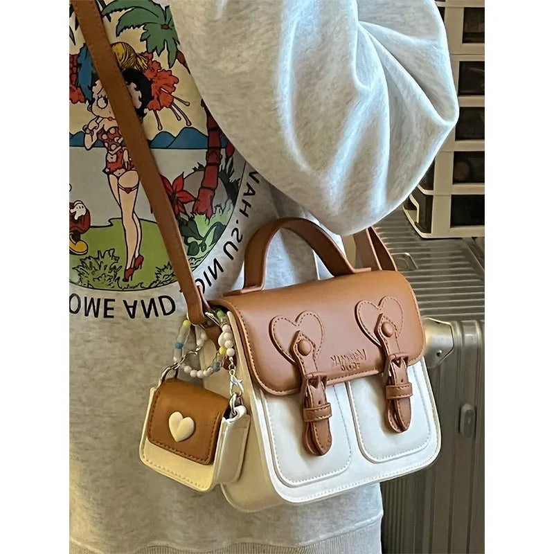 Brown leather shoulder handbag with heart buckle flap and hanging mini earphone bag