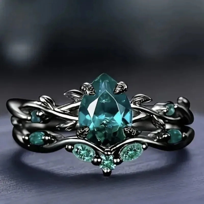 Black zinc alloy ring with green teardrop center stone and floral geometric inlay