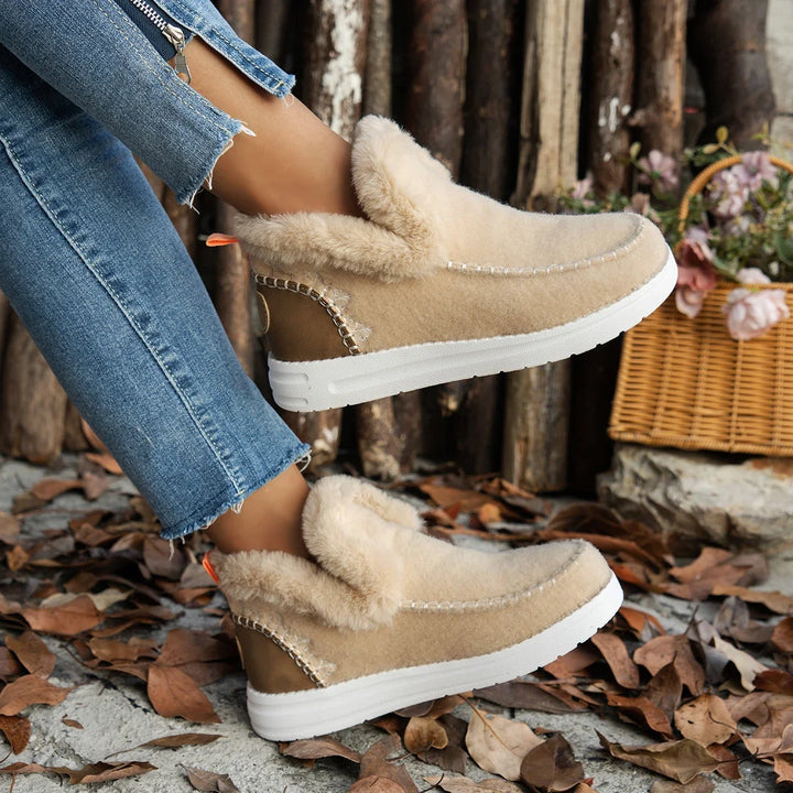 Beige suede boots with white soles worn by a person in a casual setting.