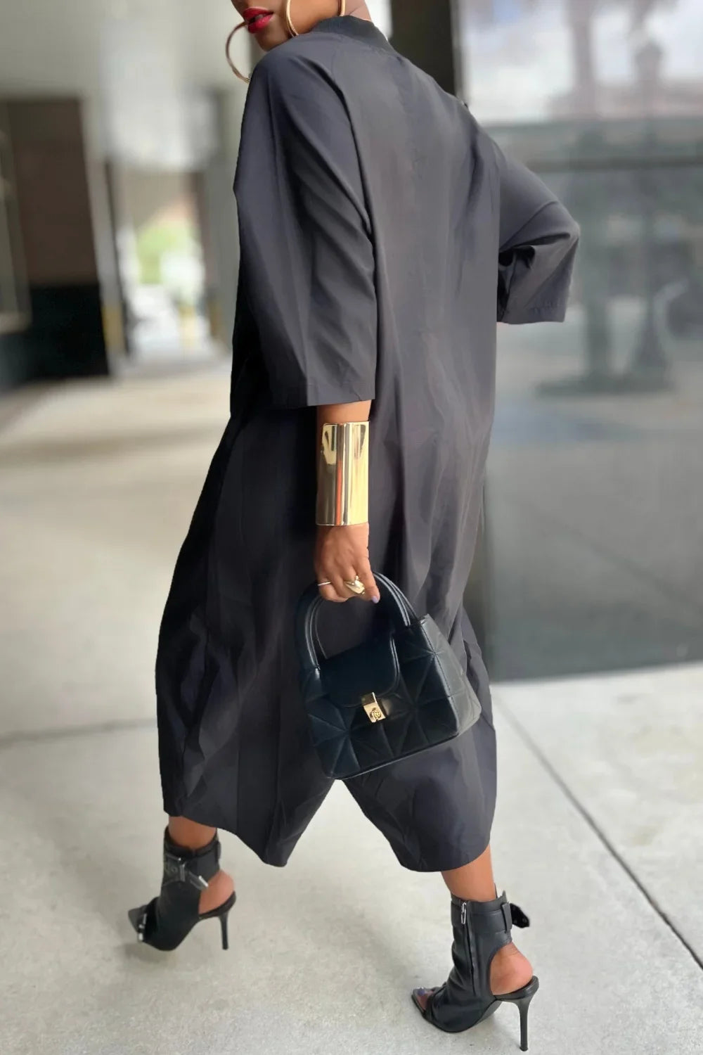 Black loose harem jumpsuit, side view with wide legs and side pockets