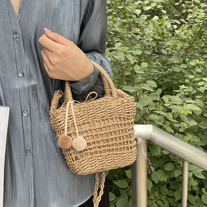 Khaki knit straw mini bucket bag with pom-pom charm and braided crossbody strap