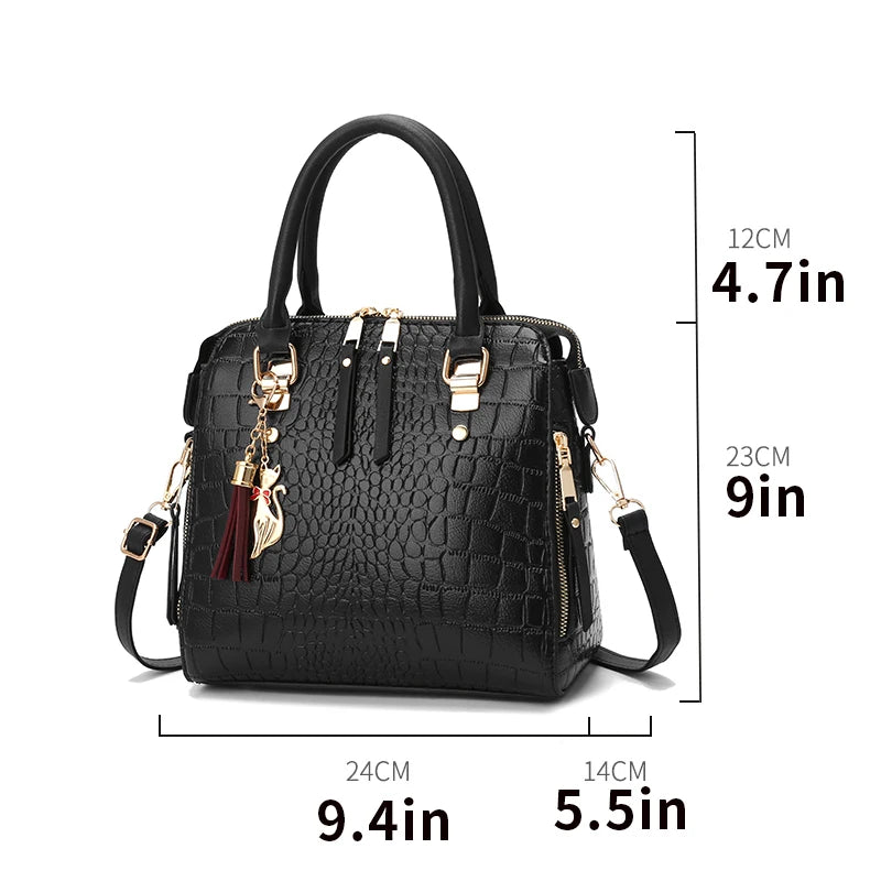 Black crocodile-embossed tote bag with top handles, shoulder strap, and gold buckles