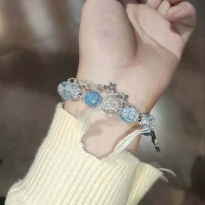 Blue crystal bead elastic bracelet with star charms and tassel dangle on hand