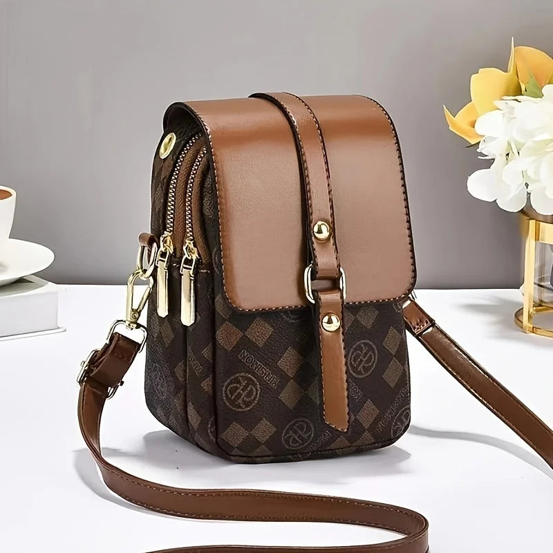 Brown patterned handbag with gold accents on a white surface
