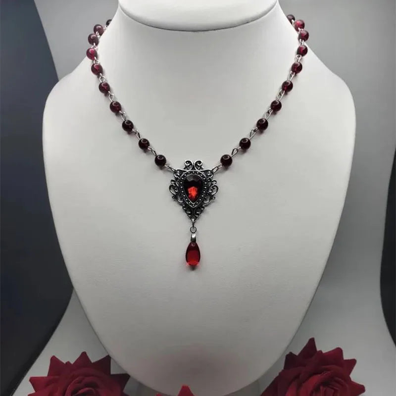 Gothic dark red bead necklace with ornate shield pendant and hanging red teardrop charm