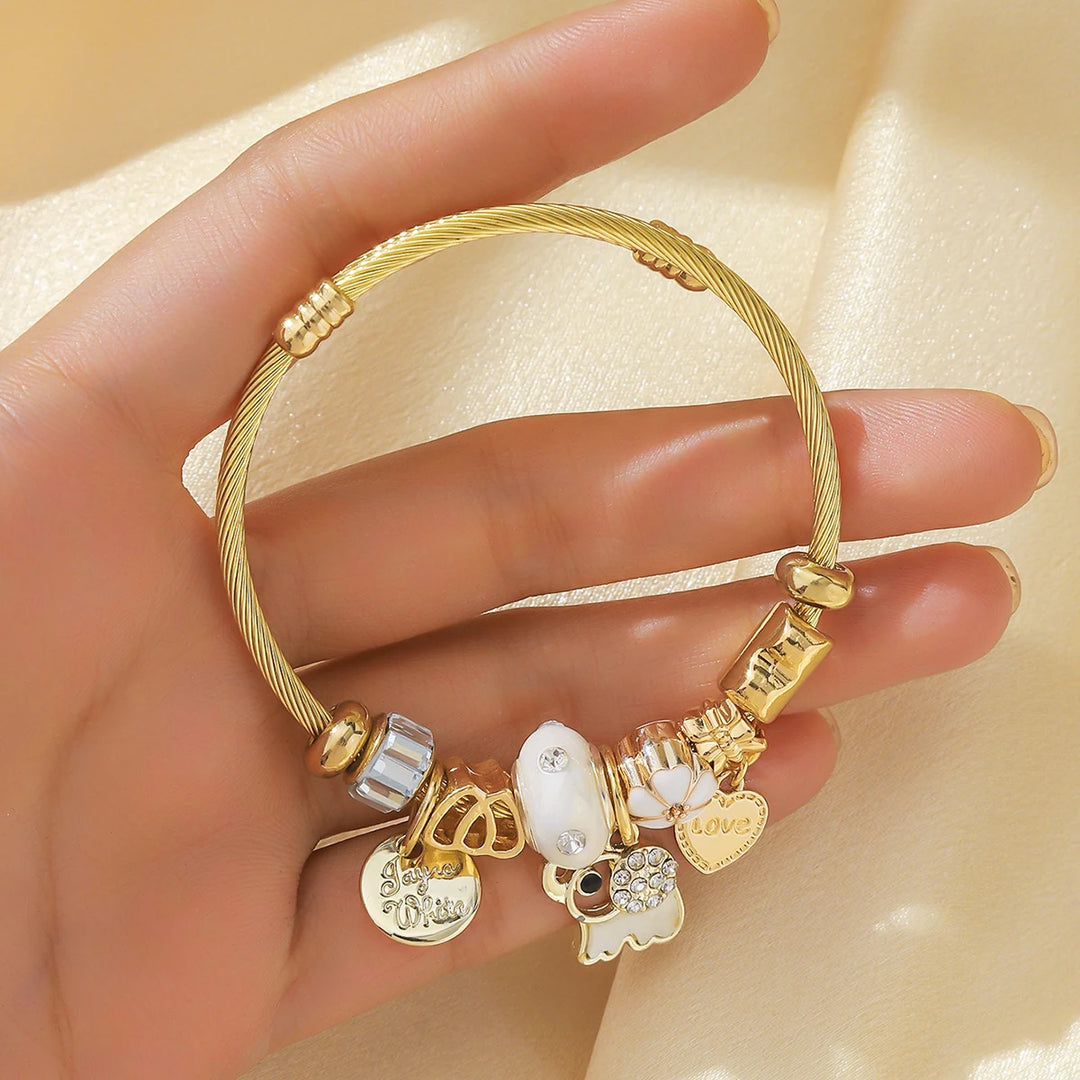 Goldfarbener Armreif mit klaren Perlen und Herzanhängern, Blick auf die Charm-Reihe