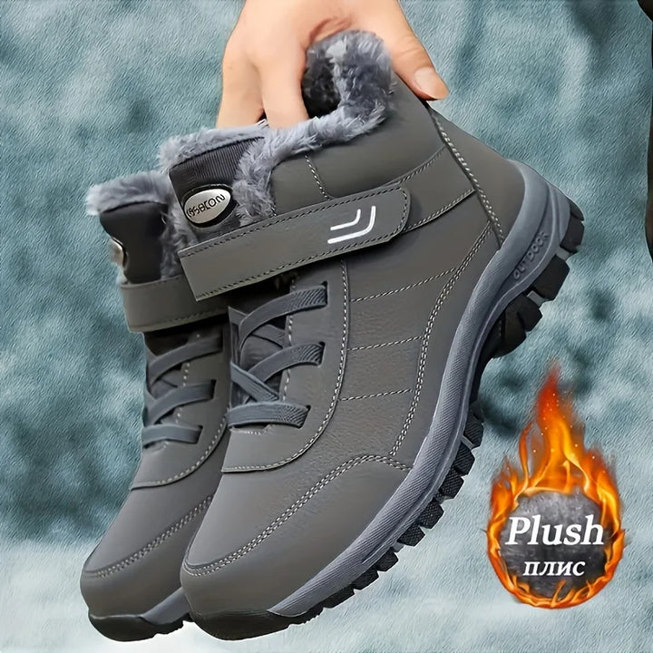 Gray winter snow boots held in hand, plush lining and hook-and-loop strap