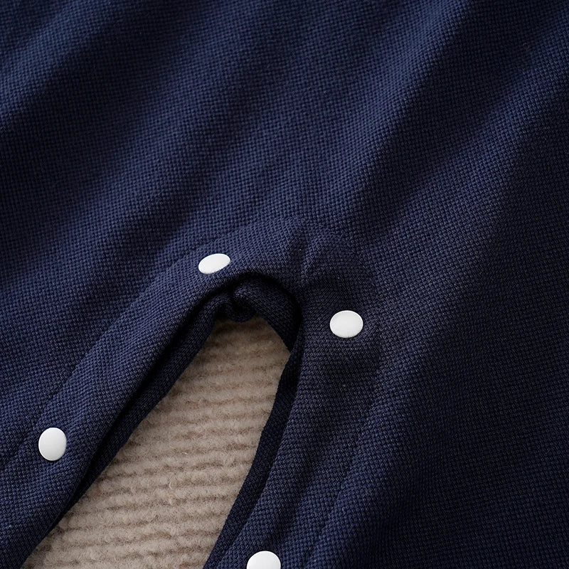 Close-up of a navy blue fabric with white buttons on a textured surface