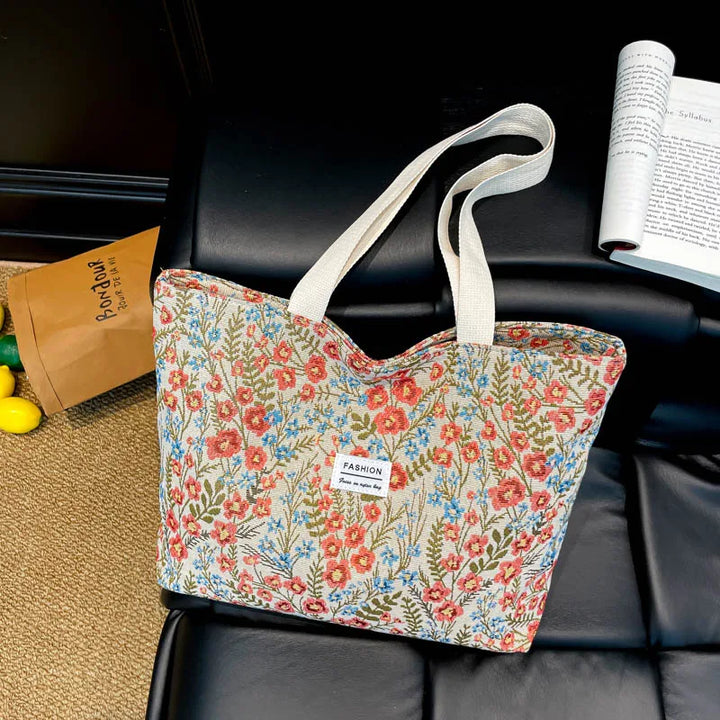Canvas tote bag with blue and red floral print and light top handles