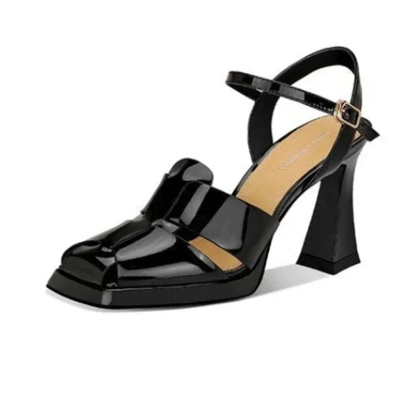Black patent leather sandal with a block heel on a white background