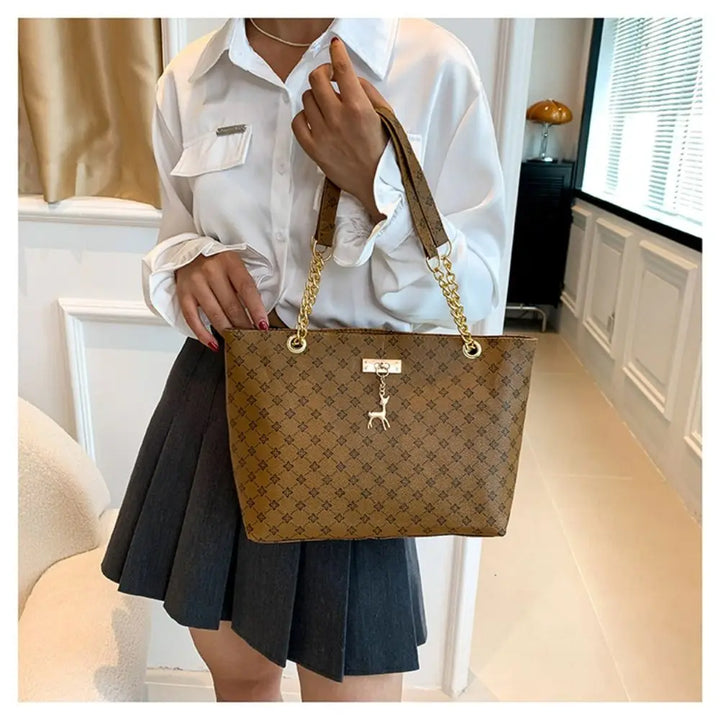 Large patterned bucket tote bag with chain handles and top clasp, tan/brown