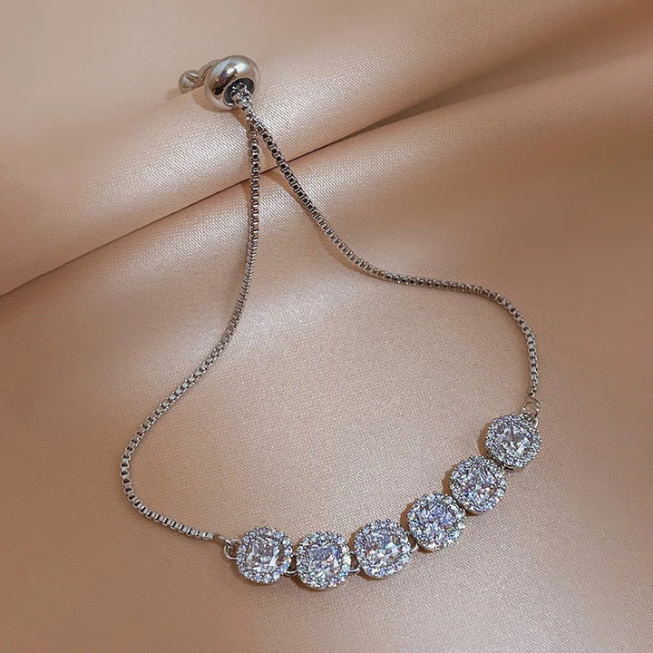 Silver-tone tennis bracelet with round pavé stones and small heart charm