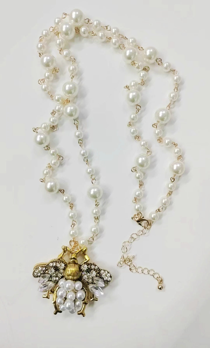 Pearl necklace with a decorative pendant on a light gray background