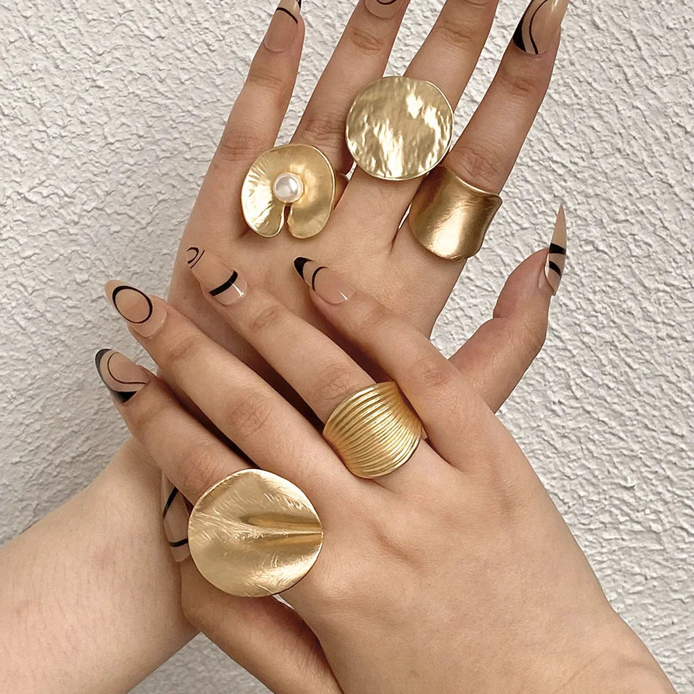 Gold tone floral mood ring with small white pearl center on adjustable band