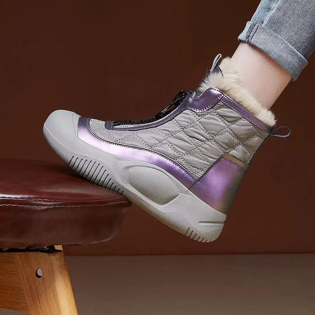 Gray and purple winter boot with fur lining worn by a person on a brown background