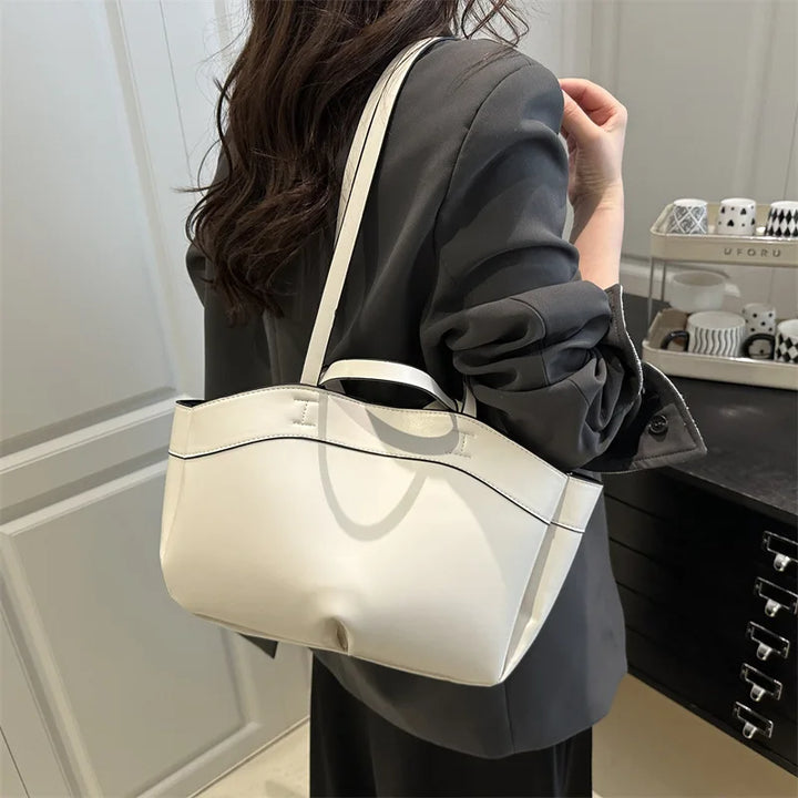 Person holding a white handbag in an indoor setting