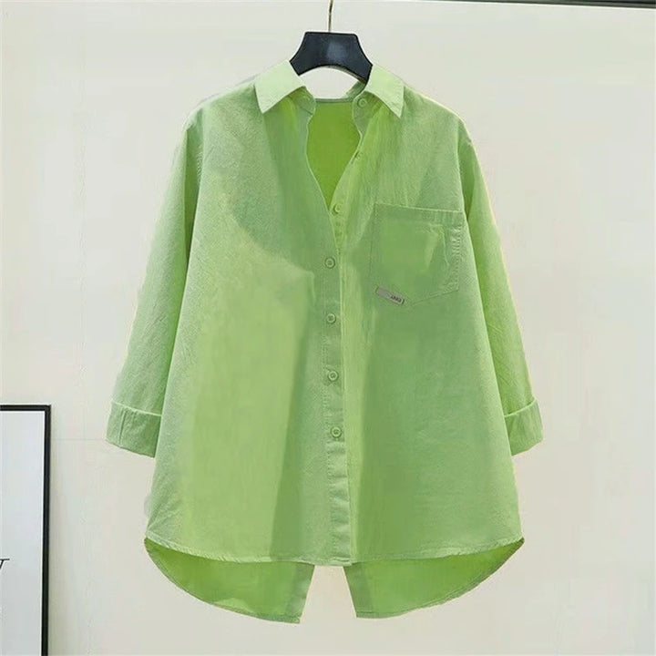 Green shirt on a hanger against a white background
