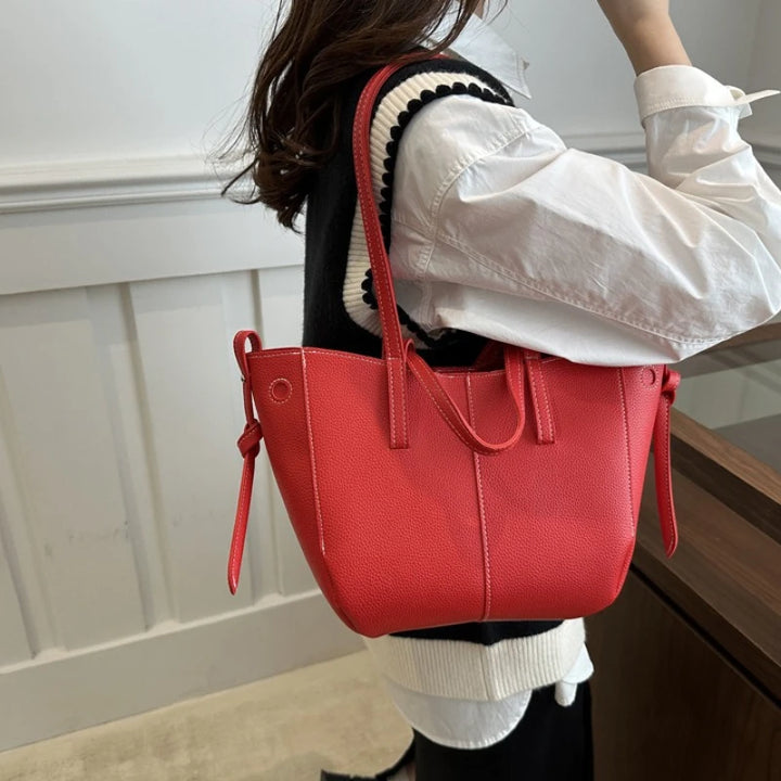 Person wearing a red handbag with a white background