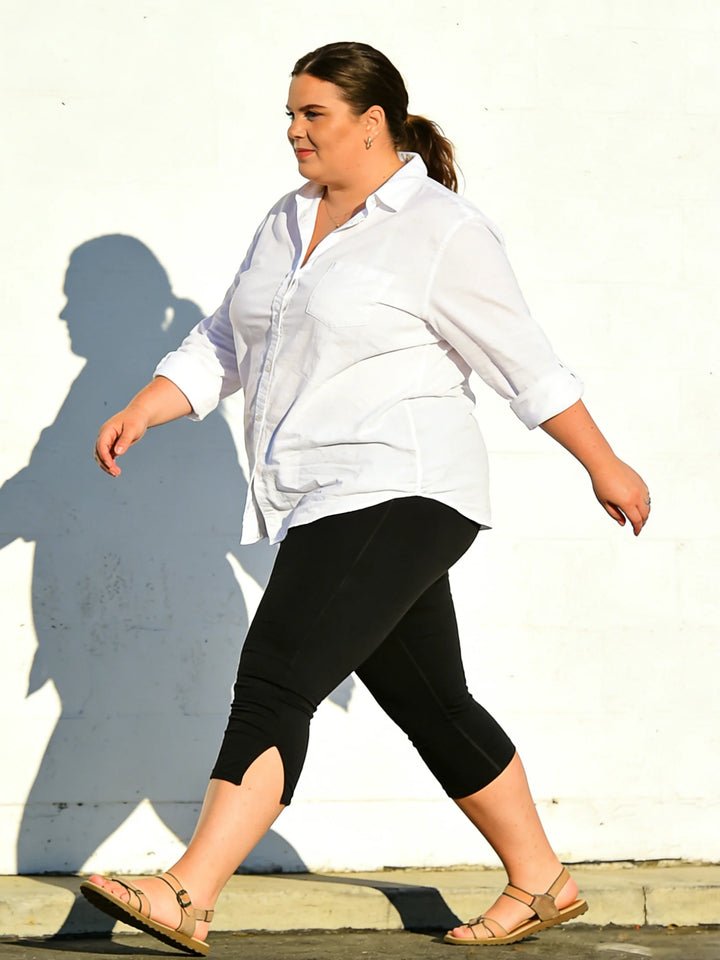 Black high-waist capri leggings with side-slit detail, front-side view