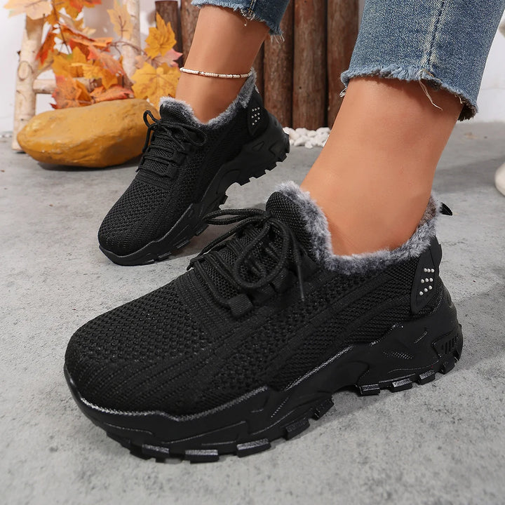 Women’s black lace-up snow sneakers with plush gray lining, worn with jeans and ankle coverage