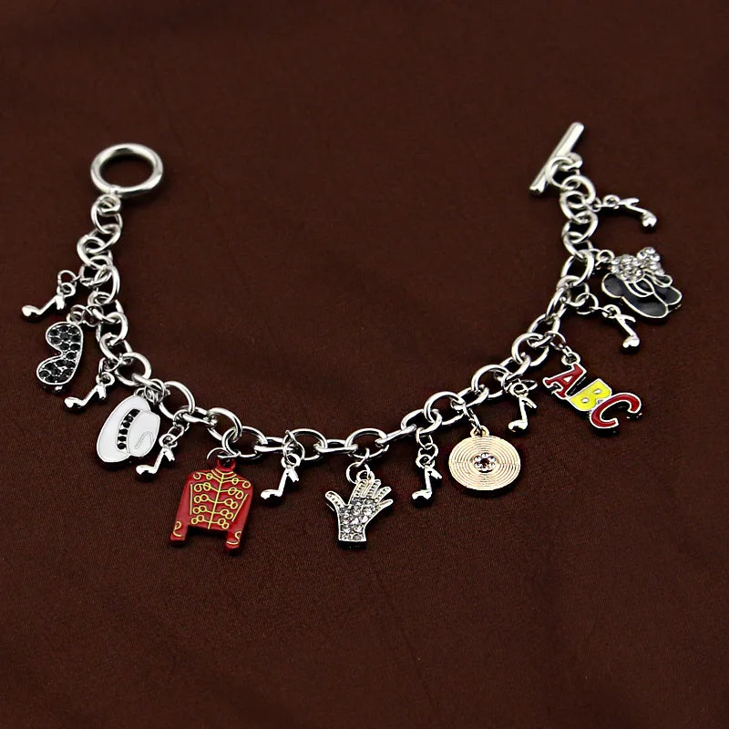 Silver-tone chain bracelet with ABC charm, red jacket, white oval face, hand, coin, music notes