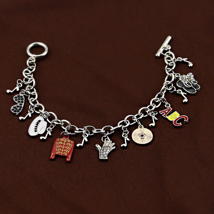 Silver-tone chain bracelet with ABC charm, red jacket, white oval face, hand, coin, music notes