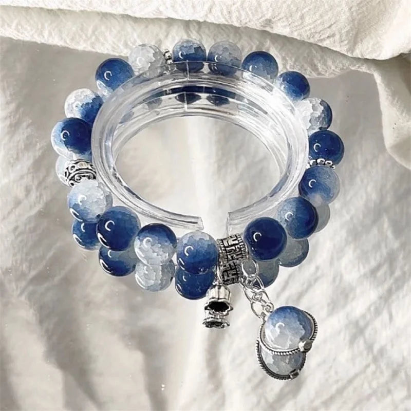 Bead charm bracelet with blue and clear beads, chain accents, and oval dangle charm