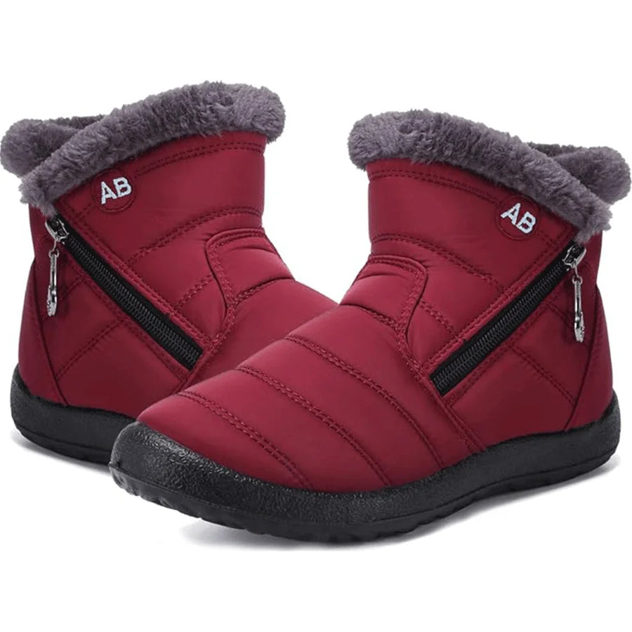 Red winter boots with gray fur trim and zippers on a white background