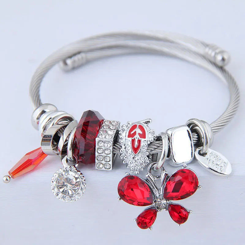 Stainless steel cuff bangle with red crystal butterfly charms and dangling red stones