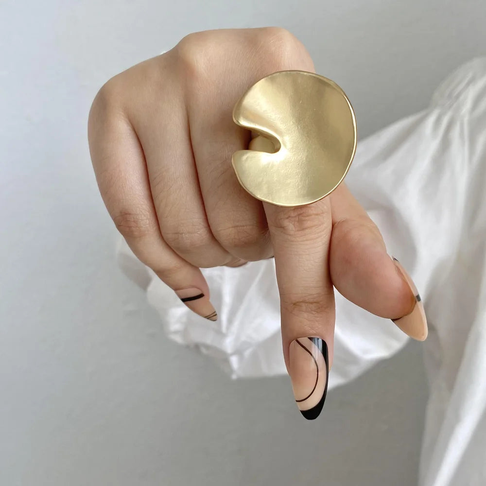 Gold sculpted statement ring with heart-shaped top, adjustable open band