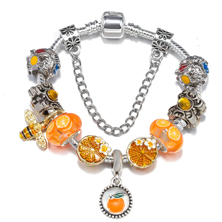 Silver charm bracelet with orange fruit and citrus-slice charms, yellow bead accents, round pendant