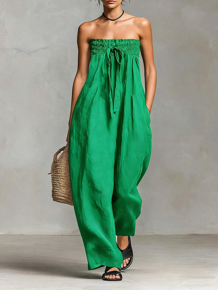 Green strapless dress worn by a person against a neutral background