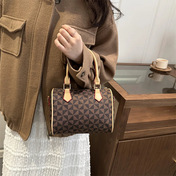Coffee-brown PU handbag with geometric triangle print, red-brown handle tabs, and adjustable strap