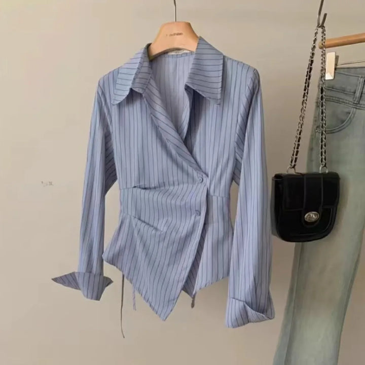 Light blue striped blouse on hanger with long sleeves and pointed collar
