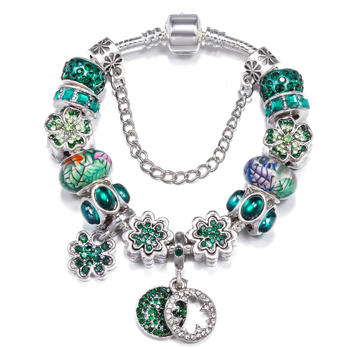 Silver charm bracelet with green crystal beads, clover charms, and heart pendant dangle