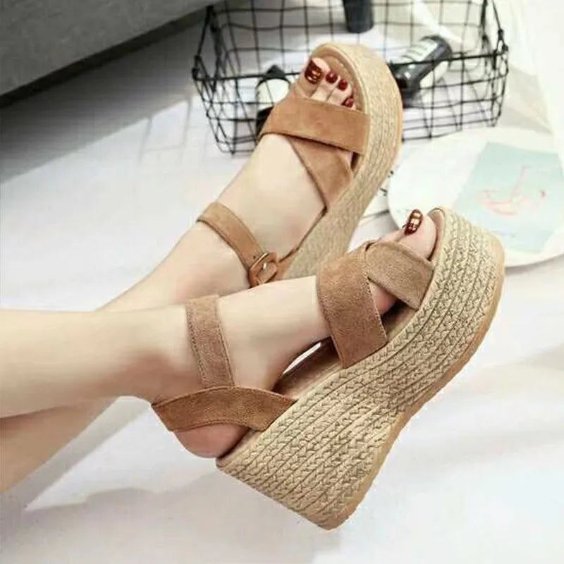 Brown wedge sandals with woven sole on a light background