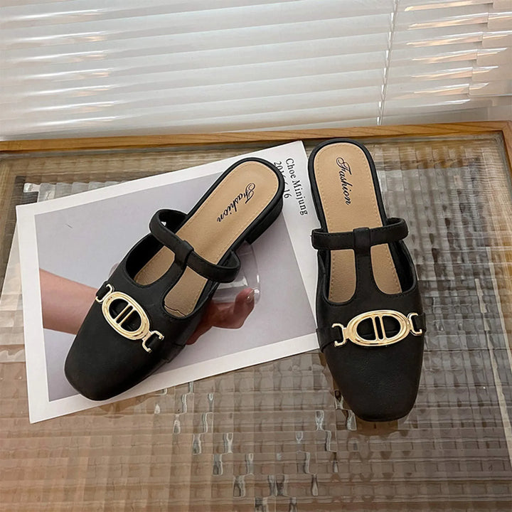 Black sandals with gold accents on a magazine