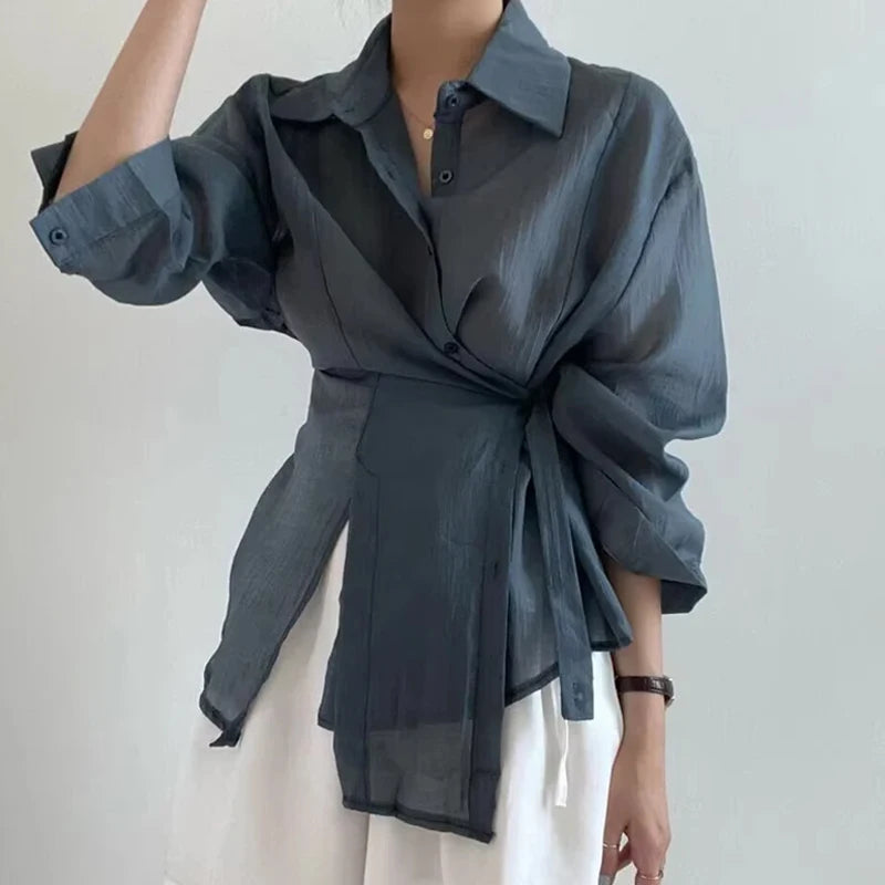 Dark gray shirt with a tie waist on a plain background