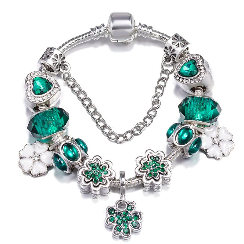 Silver charm bracelet with green crystal beads, flower charms, and dangling green heart