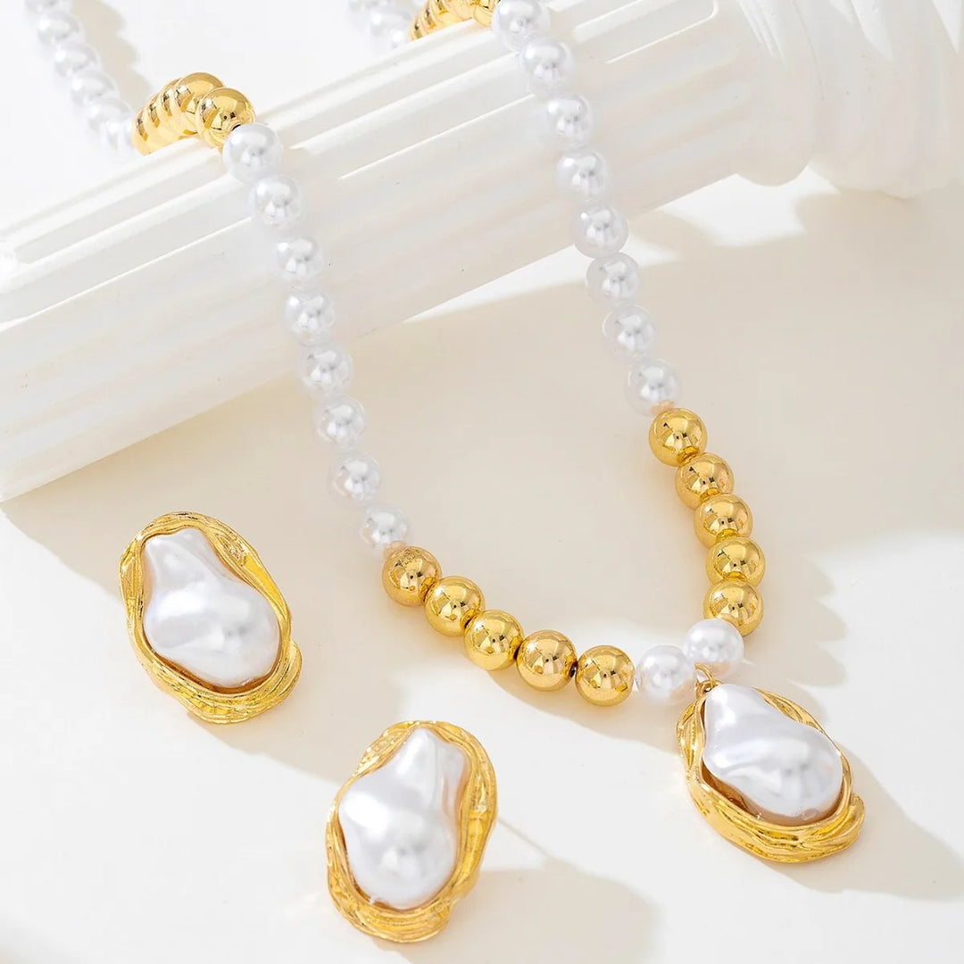 Pearl and gold necklace with matching earrings on a white surface