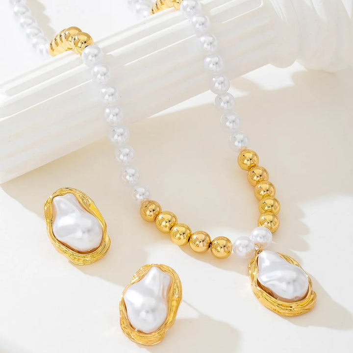 Pearl and gold necklace with matching earrings on a white surface