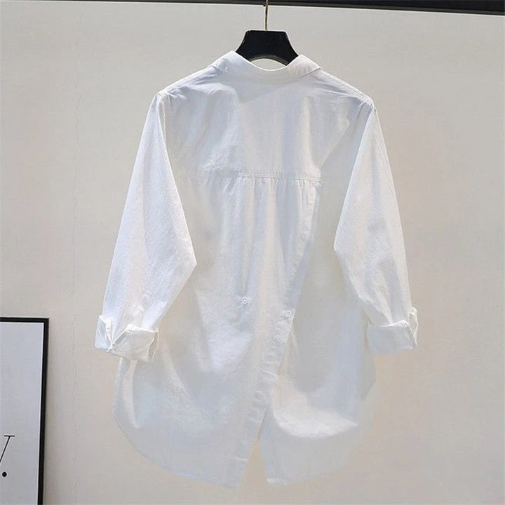 White shirt on a hanger against a plain background