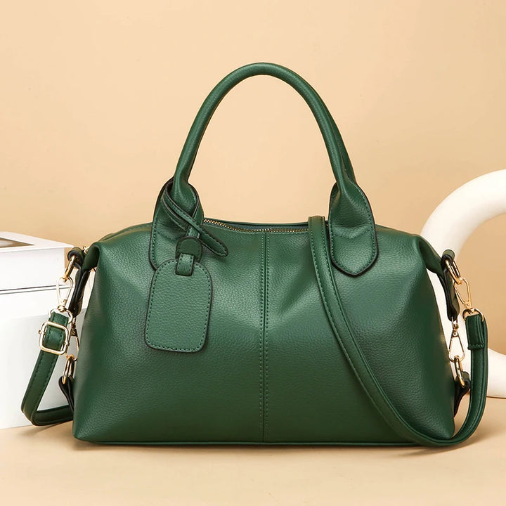 Women's soft leather tote bag in dark green with top handles and side shoulder strap