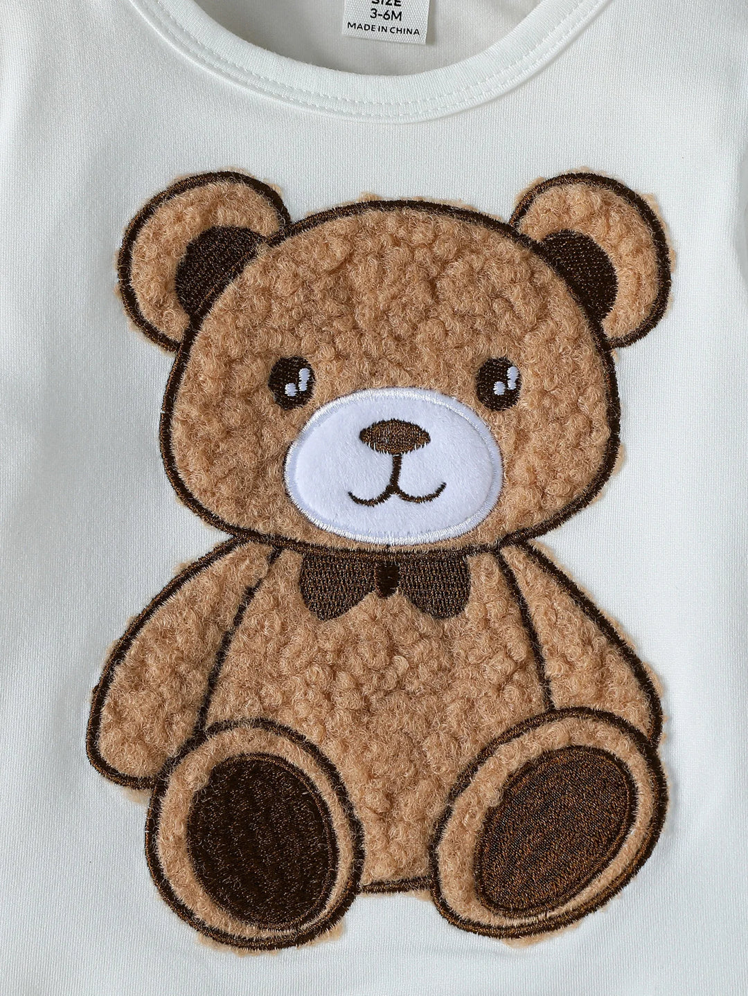 Brown teddy bear patch on a white background