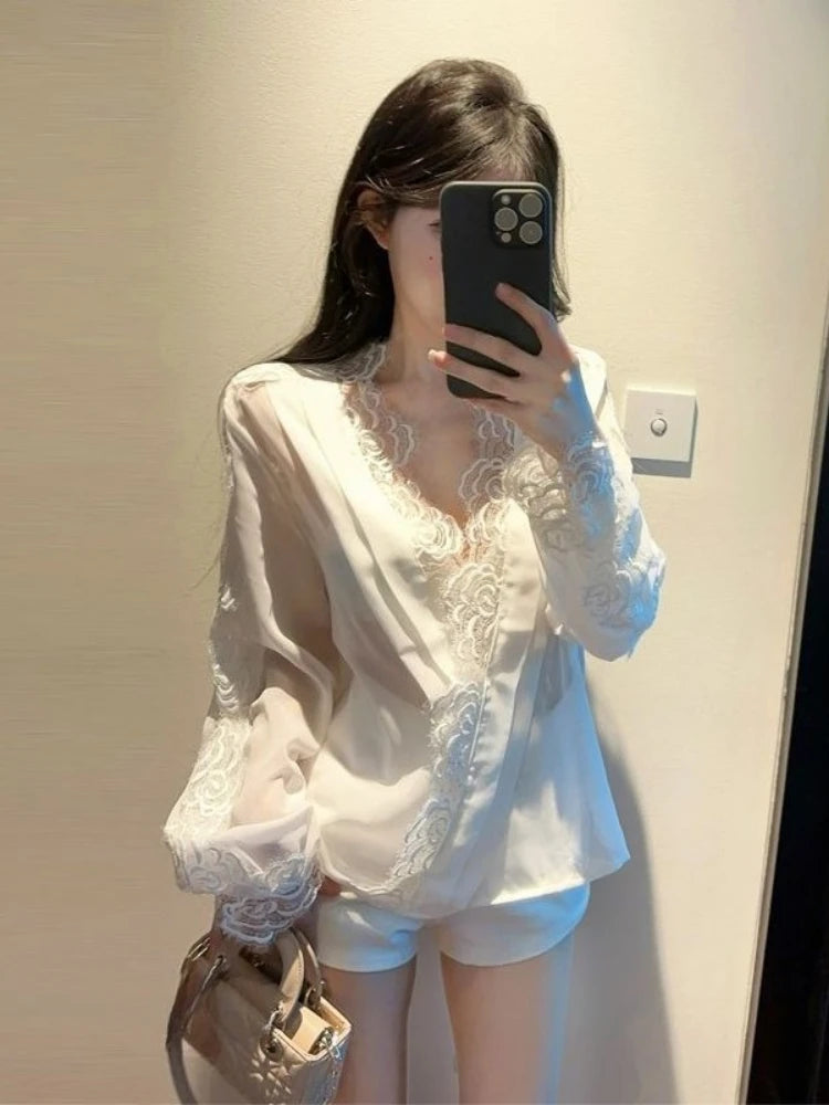 Person wearing a white lace top and shorts in front of a mirror.