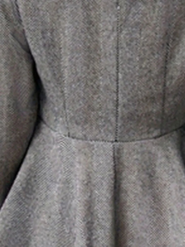 Gray coat waist seam with gathered peplum detail and textured woven fabric.