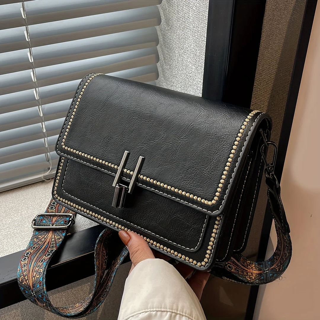 Mini crossbody bag in dark brown with flap lock, beaded trim, and patterned shoulder strap